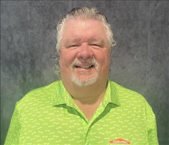 Male employee standing in front of grey backdrop